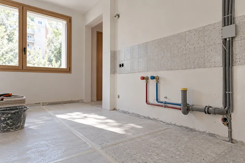 Visualización conceptual IA: Tuberías de suministro y desagüe durante la renovación de una cocina.